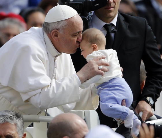 Il Papa bacia un bambino preso dalla folla
