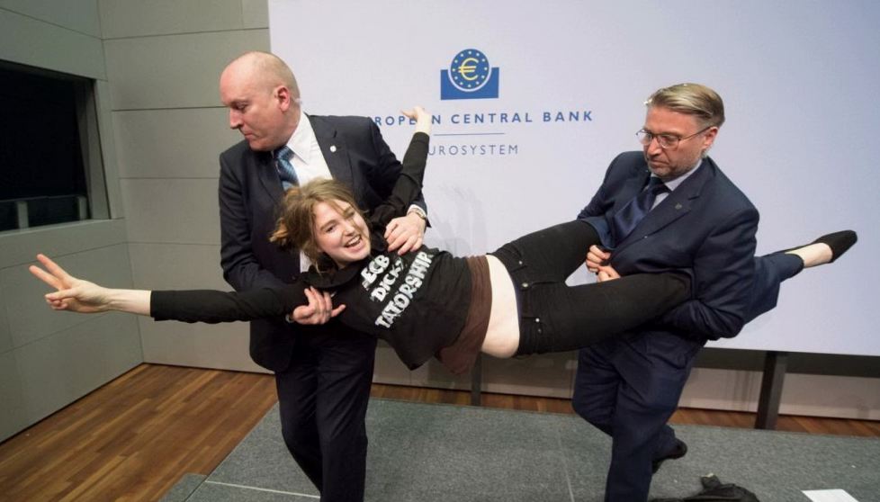 La contestatrice viene trascinata fuori dalla sala della conferenza