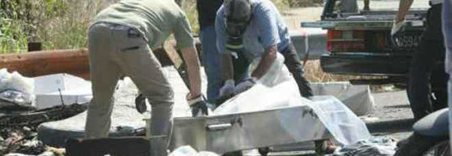 Le forze dell ordine portano via il corpo